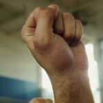 Vertical close-up of two fists raised symbolizing strength and unity.