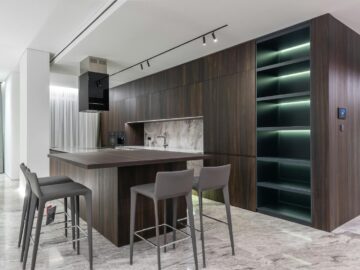 Modern interior design of contemporary spacious kitchen with dining zone and wooden furniture in apartment