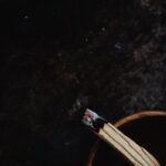 A close-up view of a burning Palo Santo stick resting in a wooden bowl; perfect for relaxation themes.