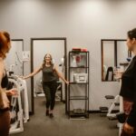Three women in a gym setting focus on fitness and wellness after midlife.