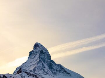 Captivating snowy peak of the Matterhorn in winter, with blue sky and scattered clouds.