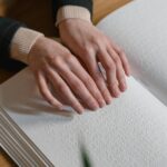 Close-up of hands reading Braille, symbolizing independence and accessibility for the visually impaired.