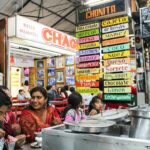 A lively Mexican ice cream shop with colorful signs and diverse customers enjoying treats.