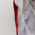 Detailed close-up of red and white ruffled fabric showcasing lace details and texture.