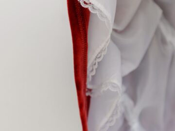 Detailed close-up of red and white ruffled fabric showcasing lace details and texture.