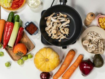 Top view of fresh vegetables, mushrooms, and kitchen ingredients on a white background, great for cooking and healthy eating themes.