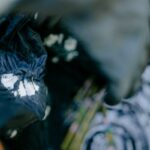 Close-up of swirling tie-dye fabric with blurred, artistic effect and water reflections.