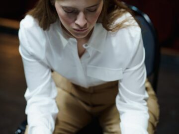 Focused young woman rehearsing her acting role on a stage, reading a script.