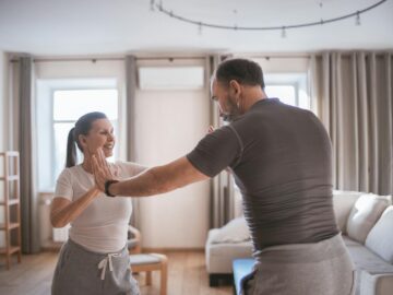 Senior couple engaging in fun exercises together at home, promoting fitness and bonding.