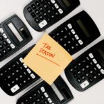 Top view of black calculators arranged around 'Tax Season' sticky note, perfect for finance concepts.