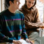 Happy couple reading Braille book, fostering connection and learning indoors.