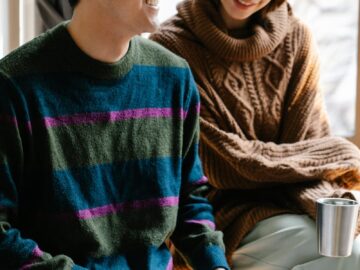 Happy couple reading Braille book, fostering connection and learning indoors.