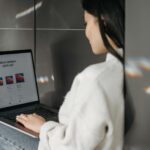Woman sitting indoors using a laptop. Casual, modern tech vibe.