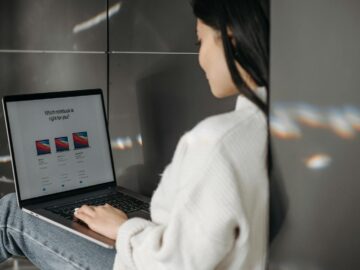 Woman sitting indoors using a laptop. Casual, modern tech vibe.