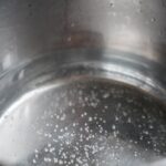 Boiling water in a stainless steel pot with visible bubbles, perfect for culinary themes.