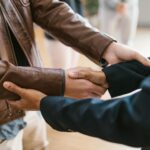 Two business professionals shaking hands, symbolizing teamwork and collaboration indoors.