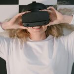 Woman lying down smiling with VR headset, embracing virtual reality indoors.