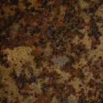 Detailed close-up of a rusty corroded metal surface showing gritty texture and brown tones.