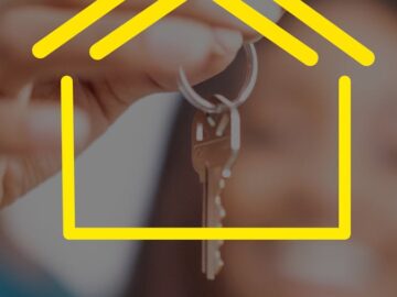 Close-up of hands holding house keys with yellow house icon overlay, representing real estate.