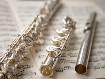 Elegant silver flutes resting on sheet music, showcasing classic musical beauty.