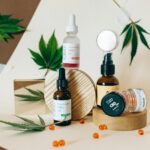 A collection of CBD oil products showcased with cannabis leaves on a neutral background.