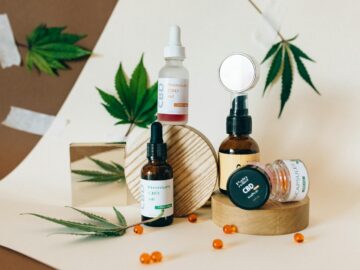 A collection of CBD oil products showcased with cannabis leaves on a neutral background.