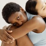 Two women posed in an intimate, minimalist studio setting, conveying unity and diversity.