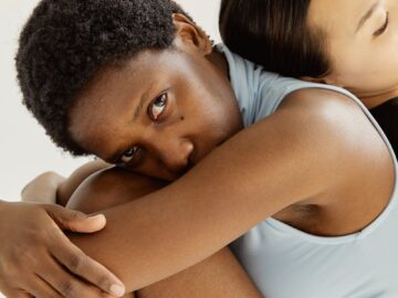 Two women posed in an intimate, minimalist studio setting, conveying unity and diversity.