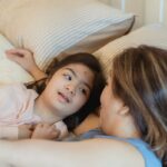 Heartwarming moment between a mother and daughter with Down syndrome enjoying a tender bond in the bedroom.