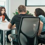 A business advisor consults with clients in a modern office setting, fostering teamwork and cooperation.