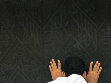 A pilgrim deep in prayer at the Kaaba in Makkah, symbolizing faith and devotion.