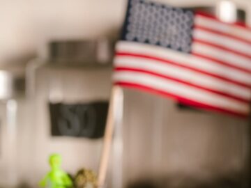 Close-up of cannabis buds with an American flag in the background, highlighting US legalization.