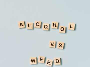 Scrabble tiles spelling 'Alcohol vs Weed' on a light blue background.
