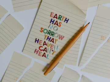 Inspiring message on a notepad with pencil, surrounded by torn paper pieces.