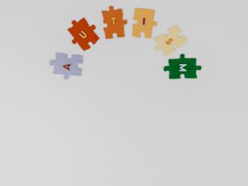 Colorful puzzle pieces spelling 'autism' on a white background symbolizing autism awareness.
