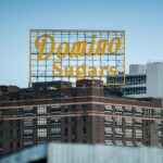 Iconic Domino Sugars sign atop a brown industrial building in Baltimore, Maryland.