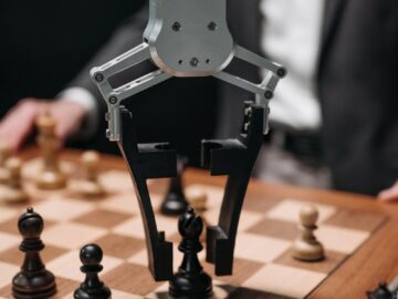 Futuristic AI robot arm making chess move during a game with a human player.