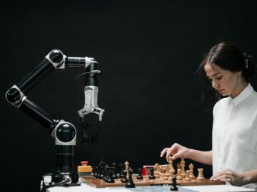 A woman plays chess against a robotic arm, showcasing AI innovation in a modern setting.