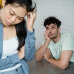 A man and woman deep in thought facing relationship tension, visible emotions in an indoor setting.