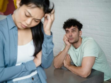 A man and woman deep in thought facing relationship tension, visible emotions in an indoor setting.