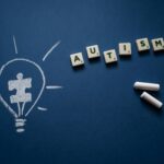 Creative still life highlighting autism awareness with scrabble tiles and chalk drawings.