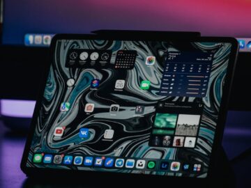 A modern tablet showcasing an abstract interface in a dimly lit environment, highlighting technology.