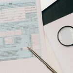 A detailed view of a tax return form with a pen and magnifying glass, perfect for financial themes.