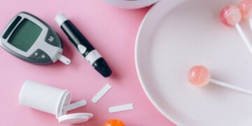 Contrasting health choices with Brussels sprouts and lollipops on a pink background.