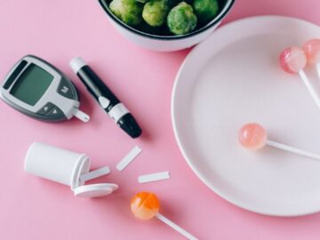 Contrasting health choices with Brussels sprouts and lollipops on a pink background.