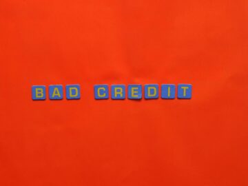 Blue letter blocks spelling 'Bad Credit' on an orange background.