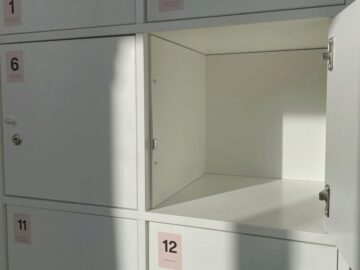 White storage locker with open door and numbered labels in soft daylight.