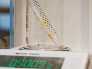 Close-up of lab equipment featuring a beaker, sample tube, and digital scale for precise weighing.