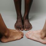 Close-up of diverse adult feet on a neutral background symbolizing unity.