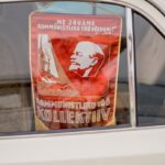 Close-up of a Soviet Communist banner in a car window with Lenin's image.